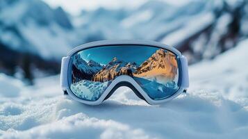 Reflective ski goggles resting on snow with stunning mountain view in the background. photo