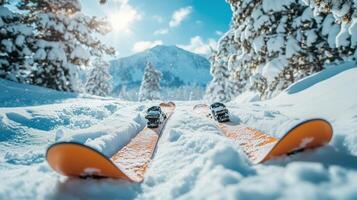 Snowy mountain landscape with skis resting on powdery snow under clear blue skies. photo