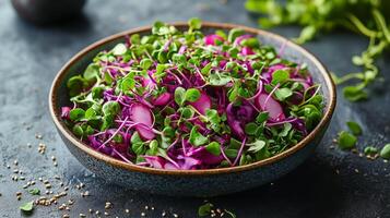 Salad with purple cabbage, microgreens, and sesame seeds on a dark surface in a contemporary setting. photo