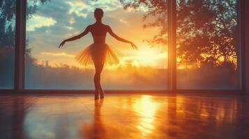 Ballerina practicing in studio during sunset with beautiful golden light. photo