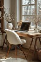 Cozy workspace with wooden desk and laptop in sunlit room with plants and decor. photo