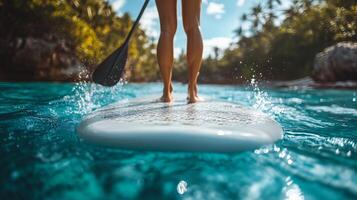 Paddleboarding in crystal clear waters surrounded by tropical greenery on a sunny day. photo