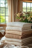Soft linen towels stacked neatly with fresh flowers in a cozy room setting. photo