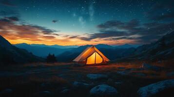 Camping at dusk in a mountain landscape with glowing tent and starry sky. photo