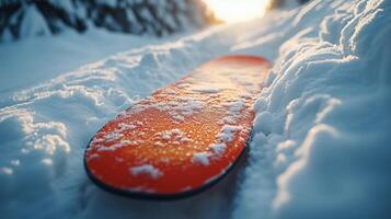 Sunny winter afternoon with a snow-covered snowboard on a mountain trail. photo