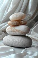 Stacked smooth stones arranged neatly on soft fabric showcases tranquility in arrangement. photo