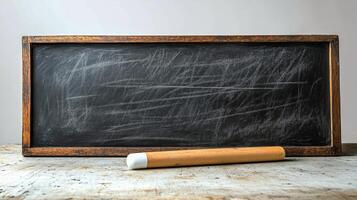 Wooden framed chalkboard with chalk resting on a rustic table surface. photo