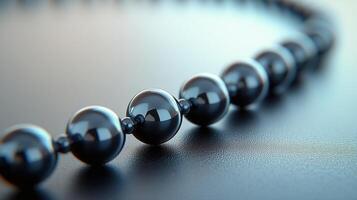 Elegant black beads arranged on a polished surface showcasing their shine and design. photo