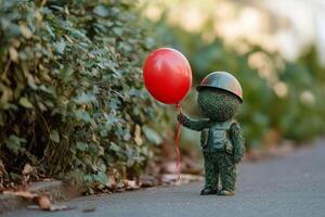 A toy soldier holding a red balloon photo