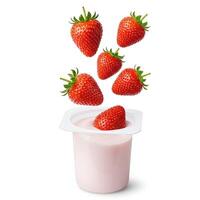 Strawberries falling into a container of yogurt photo