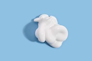 The texture of white cream on a blue background. photo