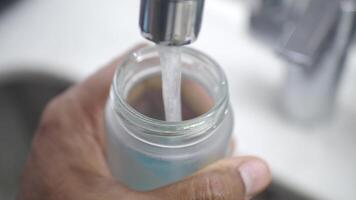 Filling a glass jar with refreshing water at the kitchen sink video