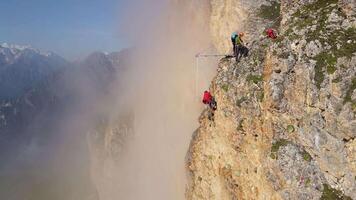 Climbers set up a springboard for jumping down on ropes on the high mountain video