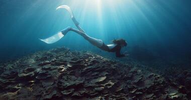 Freediving with woman in tropical sea over corals and sunlight in Raja Ampat video