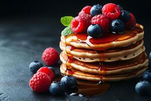Stack of Blueberry and Raspberry Pancakes Topped with Fresh Berries and Maple Syrup photo