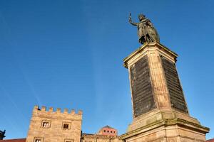 Monument to Don Pelayo in Gijon with a modern building in the background photo