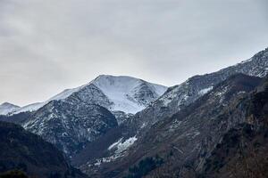 Snow covered Pena de Gata peak surrounded by rugged mountains near Pola de Somiedo photo