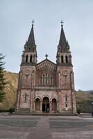Stunning view of the Basilica of Santa Maria in Covadonga, surrounded by nature and mountains photo