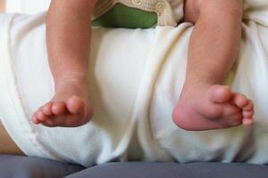 Tiny baby feet resting on soft surface, showcasing delicate toes and smooth skin. image captures moment of innocence and warmth, perfect for family themes photo