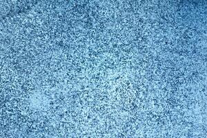 textured blue surface with speckled pattern, creating calming and serene atmosphere. This evokes feelings of tranquility and coolness, perfect for various design projects photo