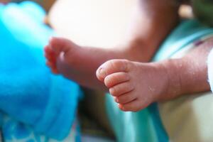 Tiny baby feet resting on soft surface, showcasing delicate toes and smooth skin. image captures innocence and warmth of early childhood photo