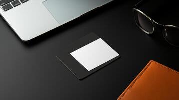 business card on sleek black desk next to laptop and glasses photo