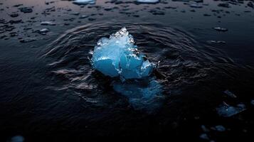 cracked iceberg floating in dark water, surrounded by melting ice photo