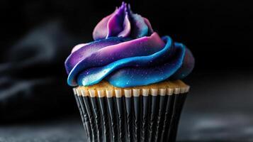 A cupcake with purple and blue frosting photo