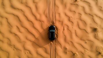 A car driving through the desert with tracks photo