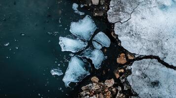 Cracked iceberg pieces floating in dark water, showcasing melting ice photo