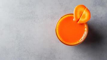 An orange juice is sitting in a glass with a slice of orange photo
