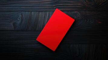 bold red card on dark wooden surface creates striking contrast photo