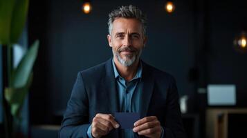 A man in a suit holding a business card photo
