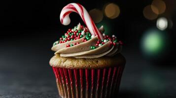 Delicious Christmas cupcake with festive sprinkles and candy cane photo
