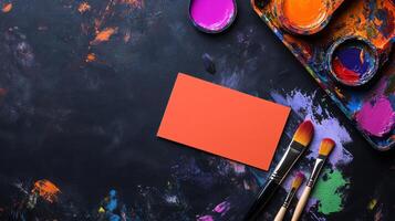 vibrant workspace with paint, brushes, and blank card for creativity photo