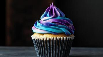 A cupcake with purple and blue frosting photo