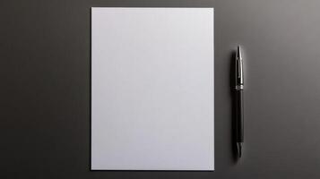 blank sheet of paper with pen beside it on dark surface, ready for notes photo