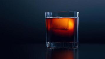 A glass of dark liquid with ice on top photo
