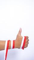 Man's Hands Wrap Around with Red and White Ribbons Showing Thumb Up on White Background photo