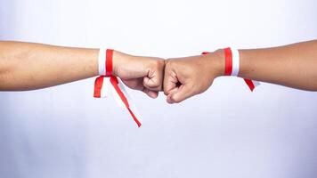 Hands Wearing Red and White Ribbons Doing Clenched High Five on White Background photo