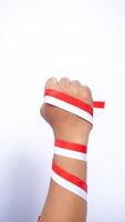 Man's Clenched Fist with Red and White Ribbons Wrapped Around The Hand on White Background photo