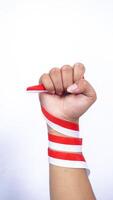 Clenched Fist with Red and White Ribbons Wrapped Around The Hand on White Background photo