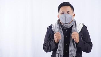 Sick Asian Man Wearing Mask and Scarf Suffering from Cold and Fever on White Background photo