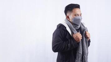 Sick Asian Man Wearing Mask and Scarf Feeling Chills on White Background photo