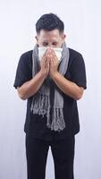 Sick Asian Man Blows His Nose with Tissue Paper on White Background photo
