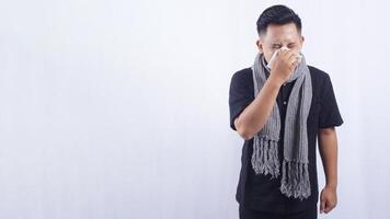 Unhealthy Asian Man Blows His Nose with Tissue Paper on White Background photo