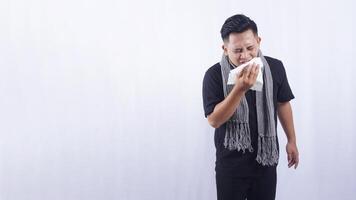 Asian Man Sneeze Into Tissue Paper Suffering from Flu on White Background photo