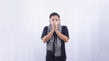 Asian Man Blows His Nose with Tissue Paper Suffering from Flu and Cold on White Background photo