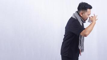 Side View of Asian Man Blows His Nose with Tissue Paper Suffering from Flu on White Background photo