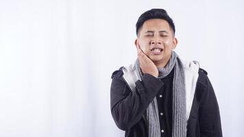 Young Asian Man Touching His Cheek Suffering from Bad Toothache on White Background photo